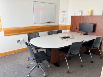 The East Study Room features a table with five chairs, a dry erase board, and a monitor on the table. The central panel built into the table contains outlets and HDMI plugs to connect to the table monitor.