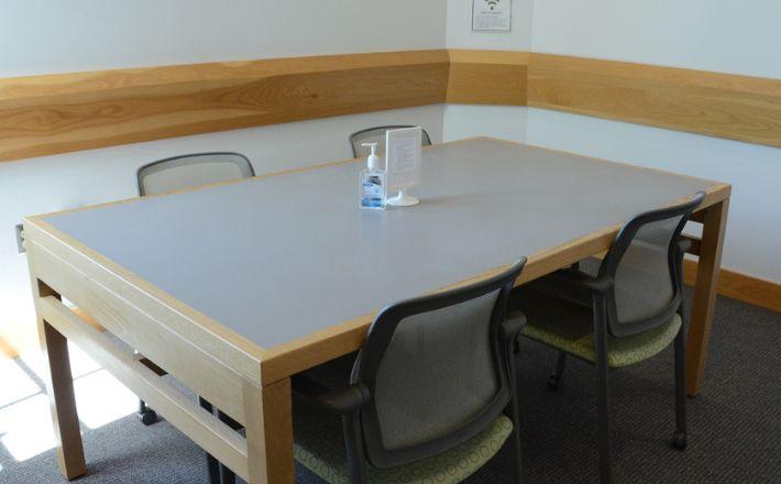 A study room with a table and four chairs.