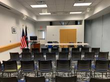 Room A with chairs in rows facing presenter or panel table at front of room; up to 80 people.
